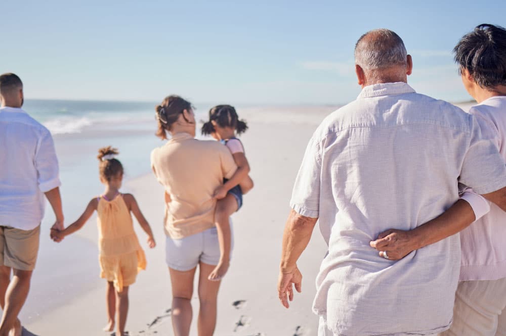 Cover image for Altrata's 2024 Family Wealth Transfer report, a picture of family members from different generations walk down the beach together